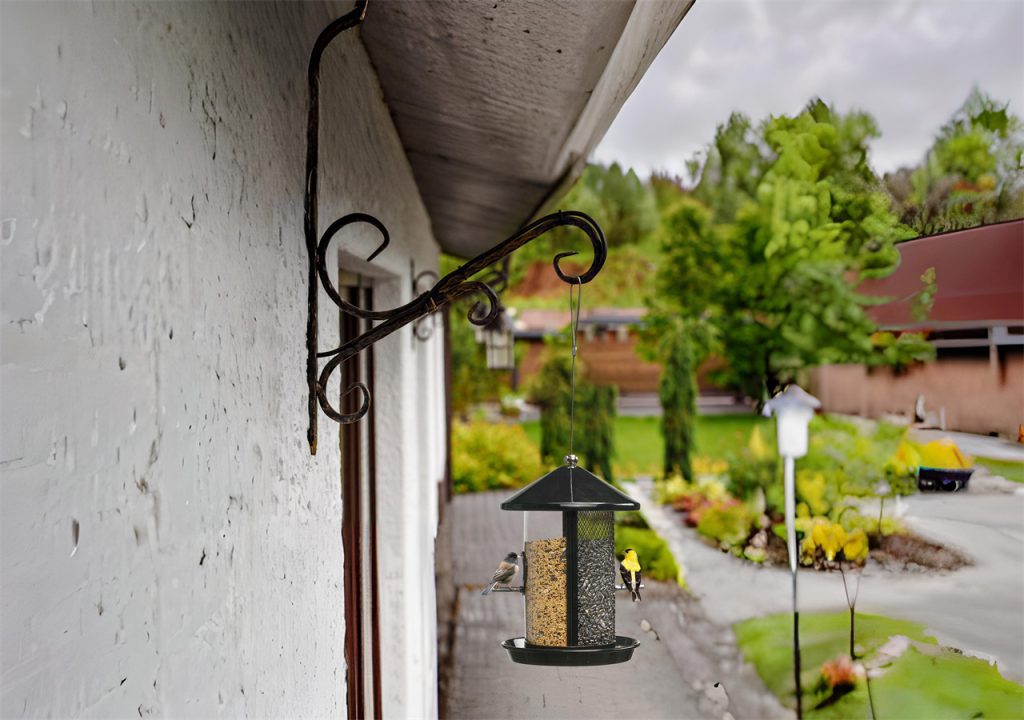 A bird feeder is hung under the eaves, and two birds are eating happily.